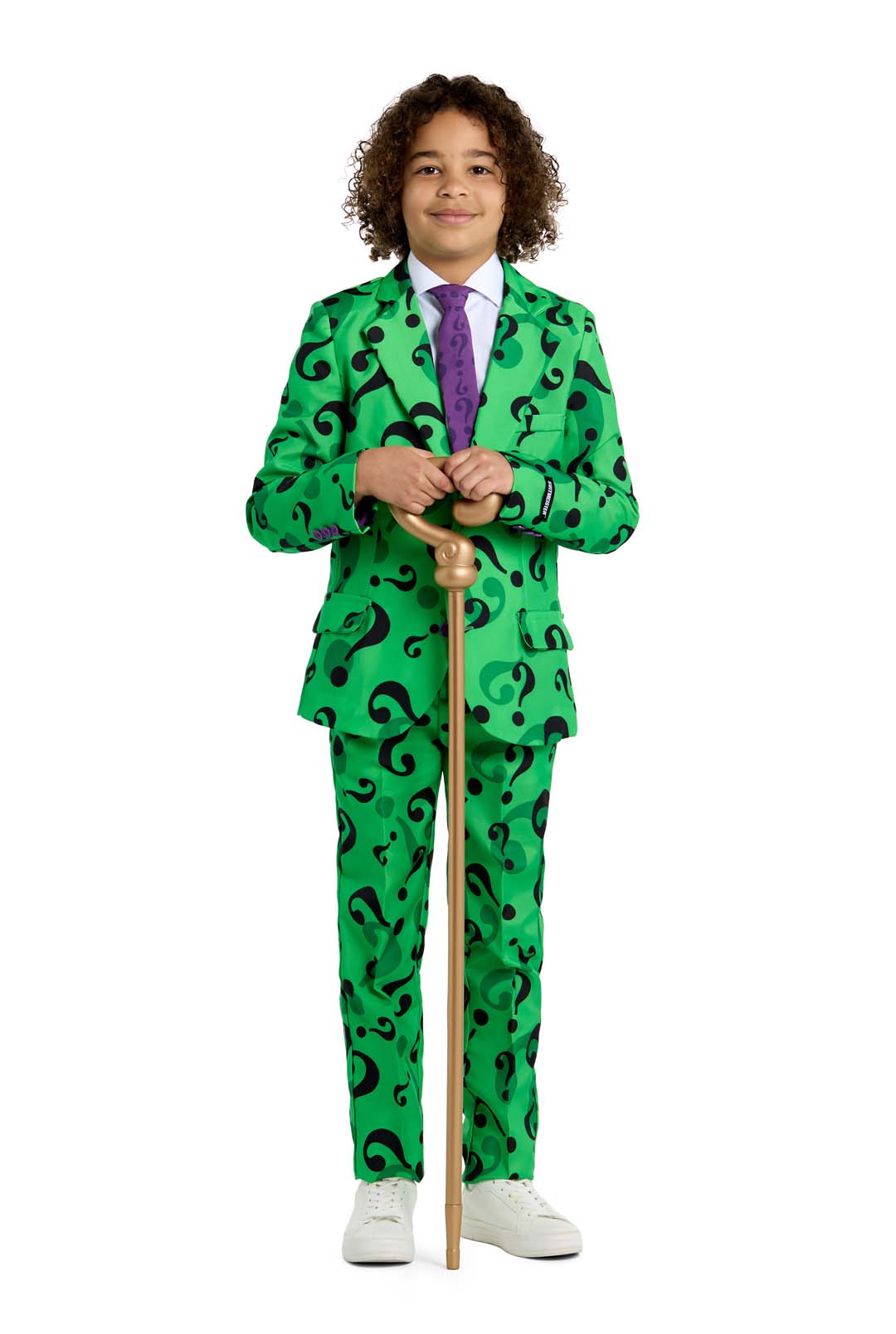 A person with curly hair is dressed in "The Riddler costume" Suitmeister suit, featuring a vibrant green design adorned with black question marks. The ensemble is completed with a purple tie and white shoes, as the individual confidently holds a wooden cane.