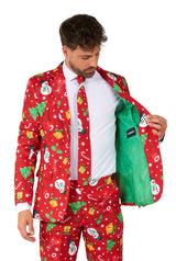 A man wearing the Suitmeister "Christmas Red Icons - Light Up" suit, featuring festive patterns of snowmen, snowflakes, and Christmas trees, is paired with a white shirt and red tie against a white background.