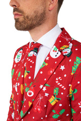 A man wearing the Suitmeister "Christmas Red Icons - Light Up" suit, featuring festive patterns of snowmen, snowflakes, and Christmas trees, is paired with a white shirt and red tie against a white background.