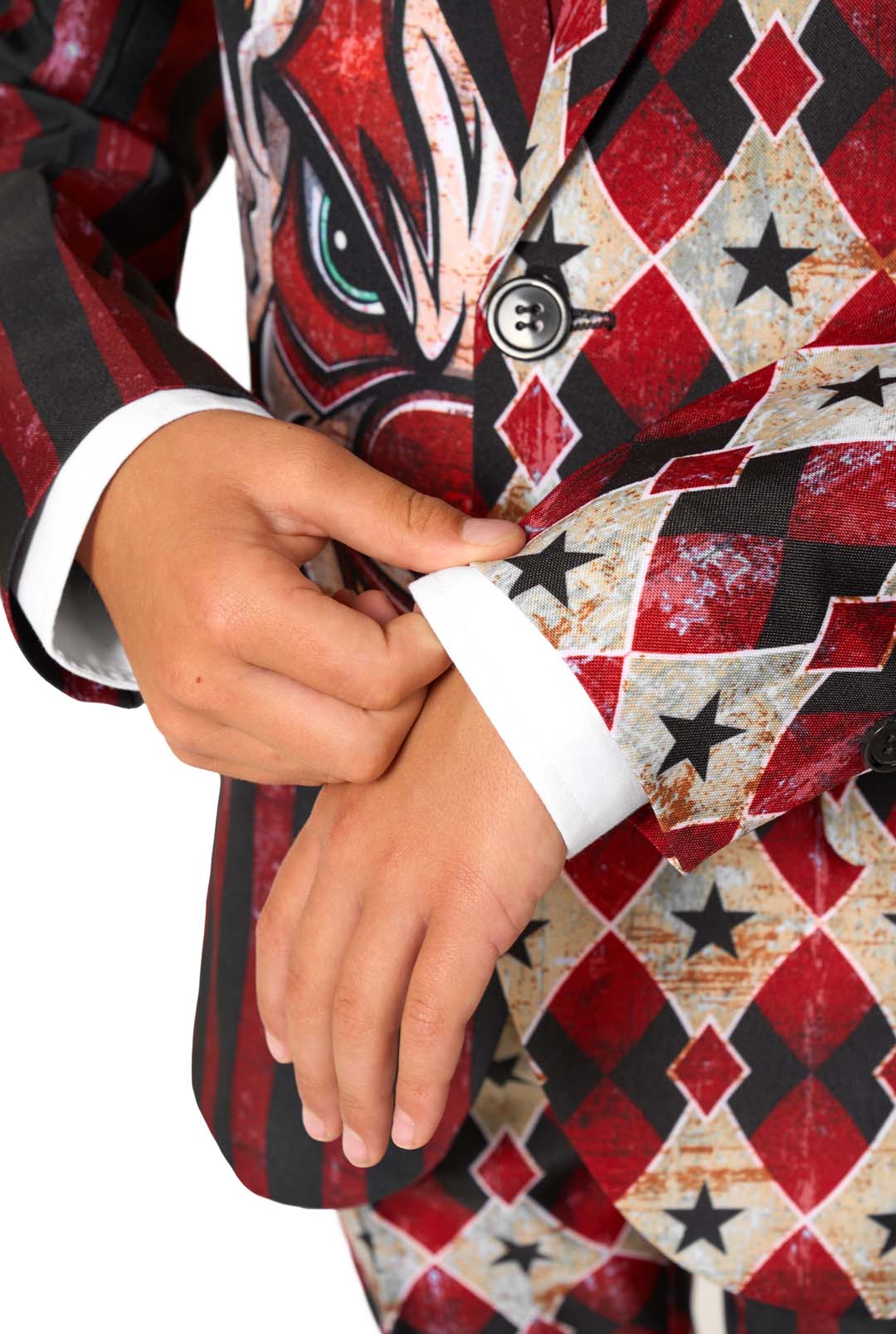 Close-up of a child adjusting the sleeve cuff of a red and black harlequin-patterned blazer.