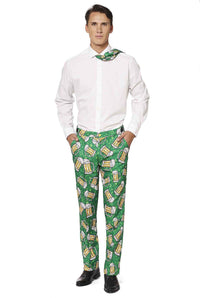 A man dressed in the Suitmeister Beer Suit, featuring a white shirt and vibrant green pants adorned with a beer mug pattern, strikes a pose with his hands in his pockets. He completes the look with a coordinating tie draped around his neck.