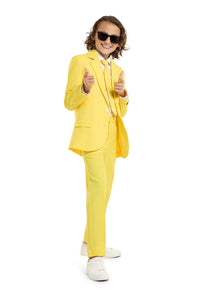 A child with a joyful expression and curly hair is wearing the Solid Yellow suit by Suitmeister, complete with a matching tie, set against a white background.