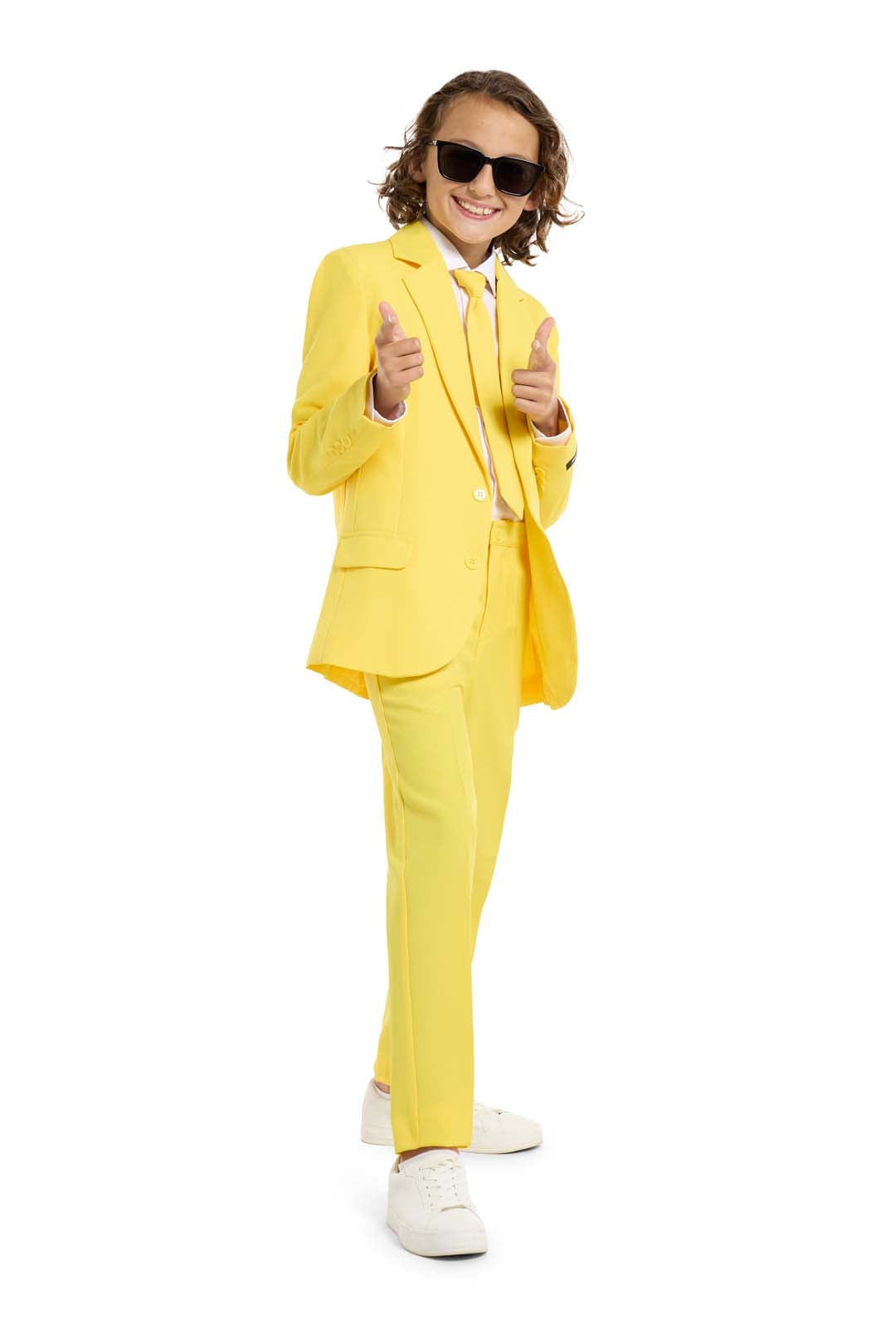 A child with a joyful expression and curly hair is wearing the Solid Yellow suit by Suitmeister, complete with a matching tie, set against a white background.