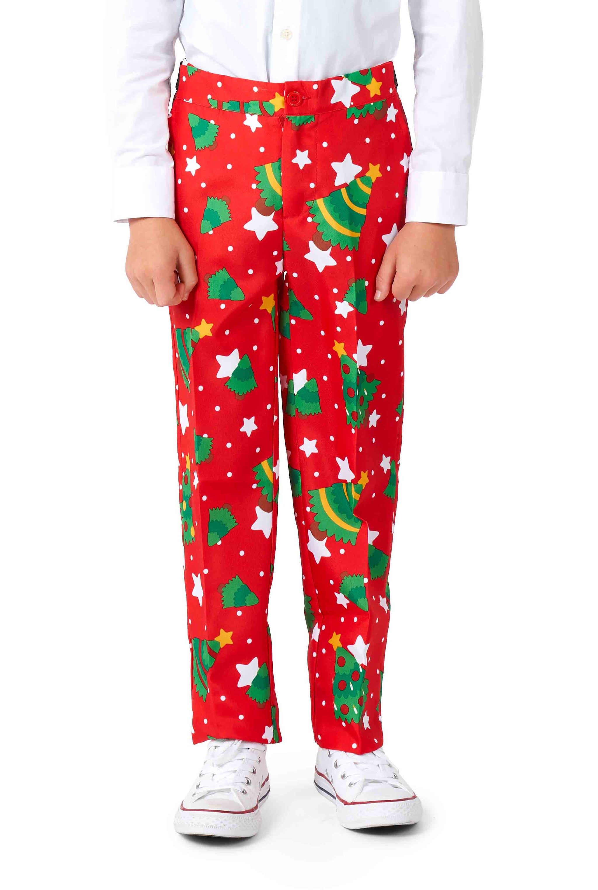 A child wearing a white shirt and eye-catching vibrant red Suitmeister pants that feature a festive Christmas Trees Stars pattern. The child also sports white sneakers.