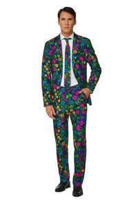 A man wearing the Suitmeister Floral, a vibrant suit adorned with a colorful floral pattern featuring blue, pink, green, and yellow flowers. He complements it with a white shirt, black tie, and black shoes while standing against a plain white backdrop.