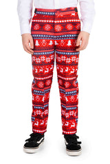 A child dressed in Suitmeister's "Nordic Pixel Red" pants, featuring a festive Christmas pattern of snowflakes, trees, and reindeer, paired with a white shirt and black sneakers.