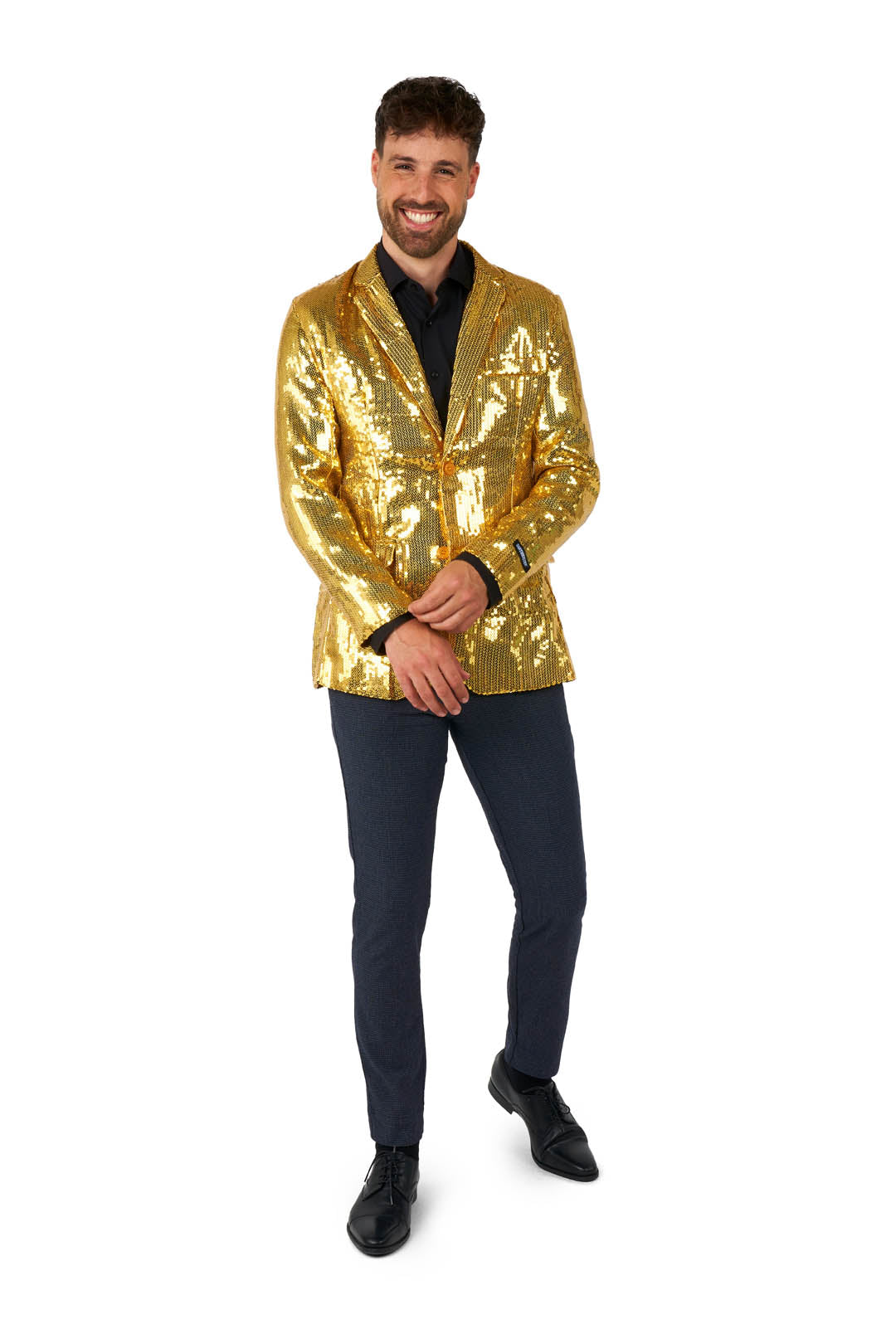 A man is standing in a Suitmeister Sequins Blazer Gold over a dark shirt and navy trousers. He is smiling, with his hands clasped in front of him, set against a plain white background.